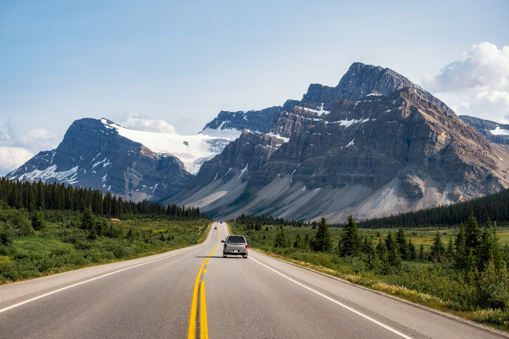 A car drives toward mountains