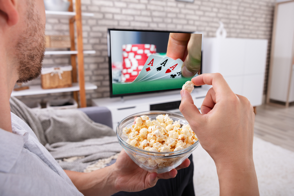  un homme avec du popcorn regarde une action de casino sur un écran