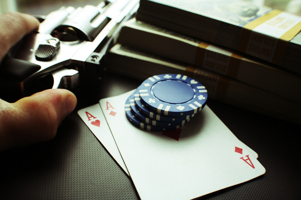 De l'argent liquide, des cartes à jouer, des jetons de poker et un pistolet