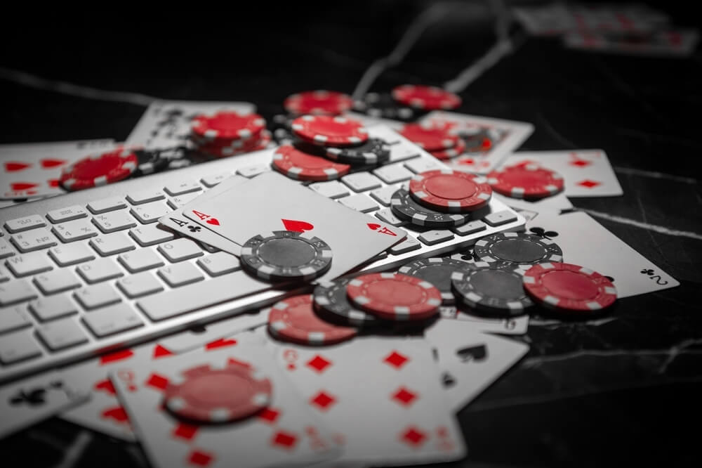 playing cards and poker chips on laptop