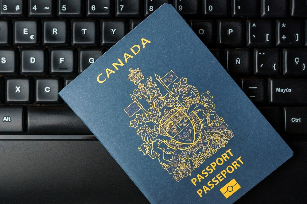 a canadian passport lies on a computer keyboard