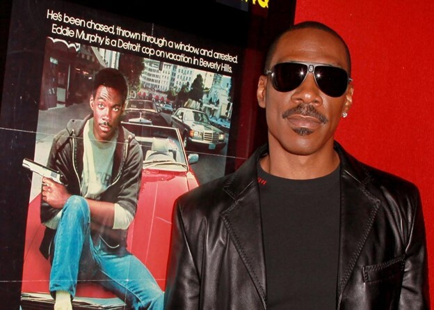 Eddie Murphy in front of the Beverly Hills Cop poster