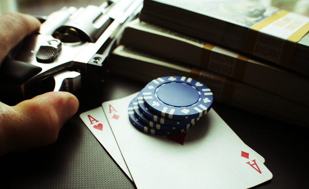 A gun, playing cards and poker chips