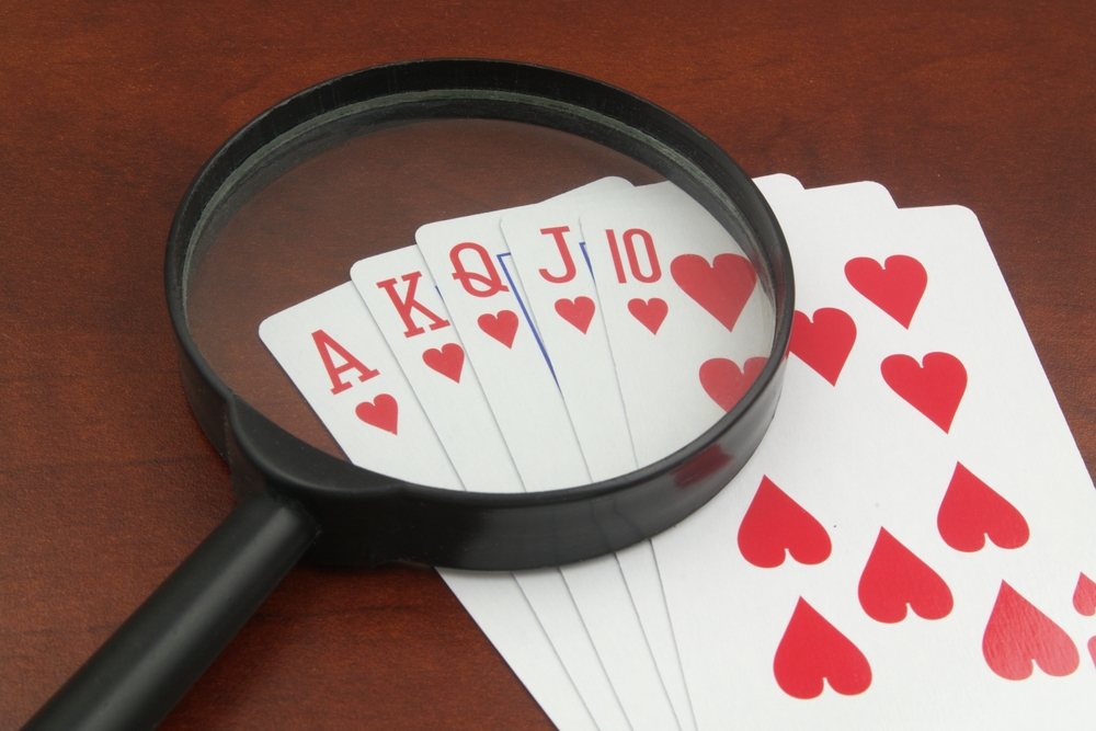 Royal flush hearts, and magnifying glass